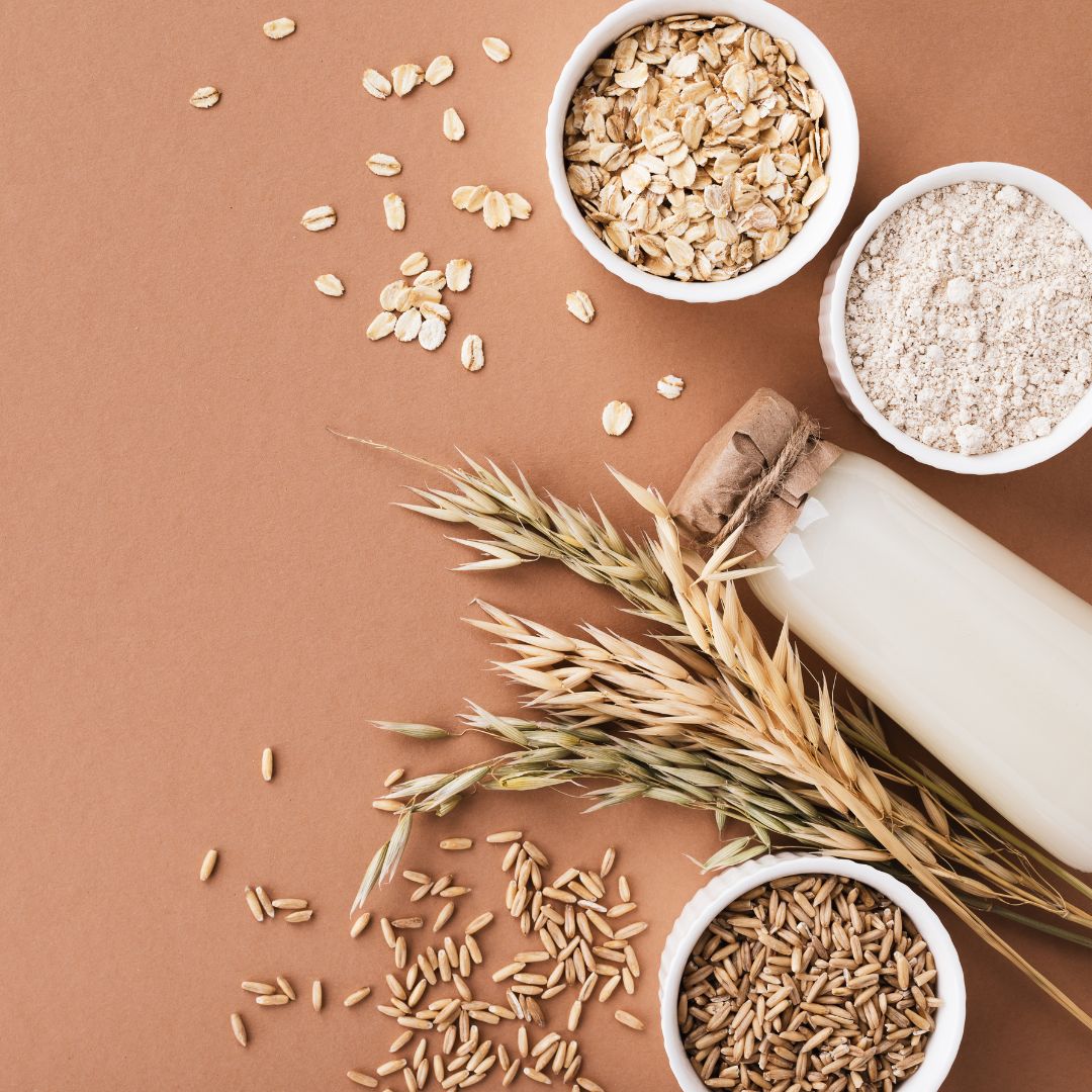 a spread of wheat berries, oats, flour with a salmon color background