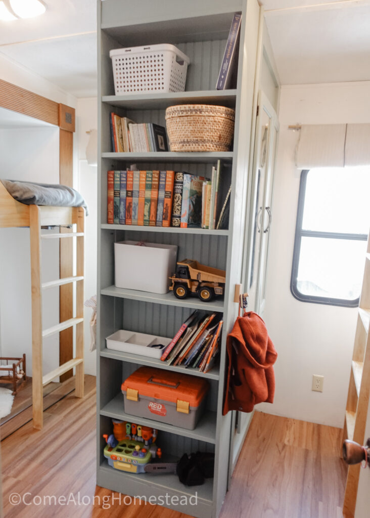 floor to ceiling bookcase in rv used to store books, toys, and baskets