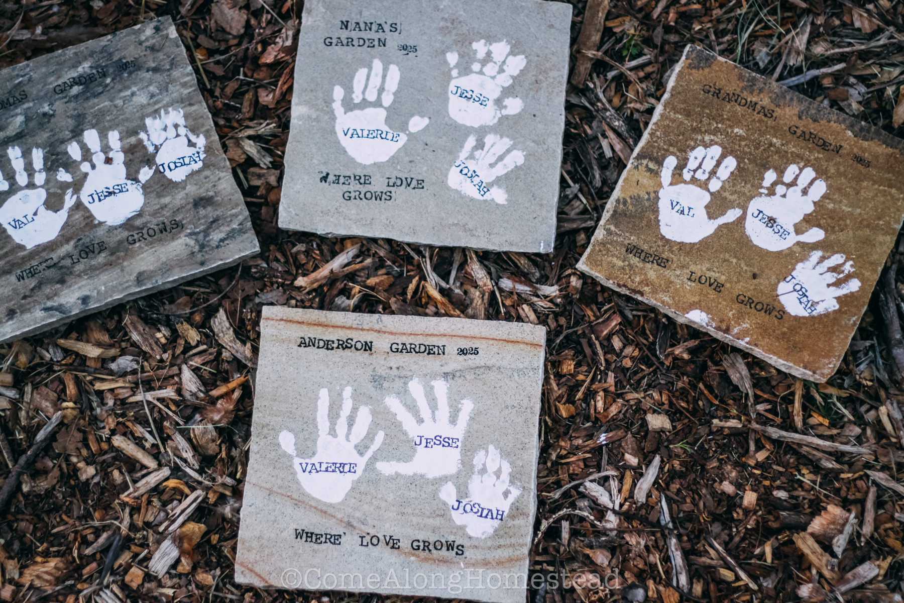 four stepping stones with white handsprints and sayings of "our garden 2025: where love grows"